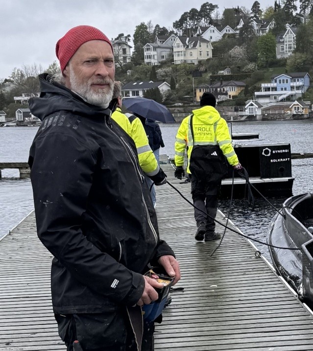 Mann med rød lue på brygge